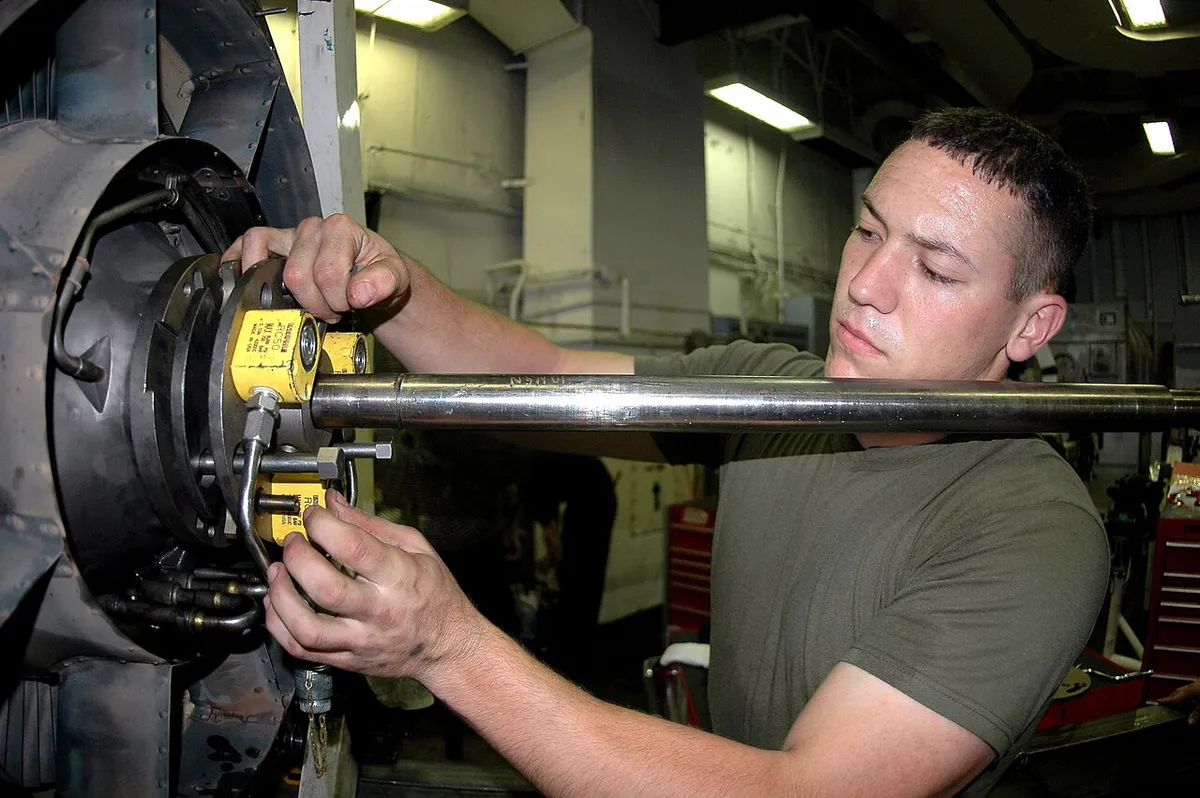 Technician performing maintenance on a jet engine