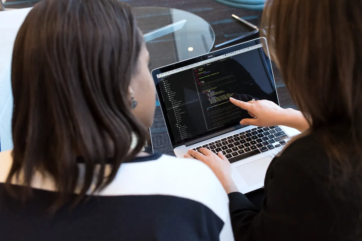 Deux ingénieures en revue de code sur un ordinateur portable